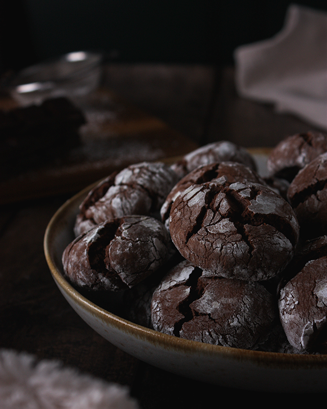 Une assiette de snickerdoodle, biscuit en chocolat recouvert de sucre glace.